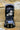Image of a Squire Keykeep™1 black die-cast alloy steel heavy-duty and high security 4 wheel recodable combination lock outdoor key safe fixed on a brick wall, fully open with a set of keys stored inside.